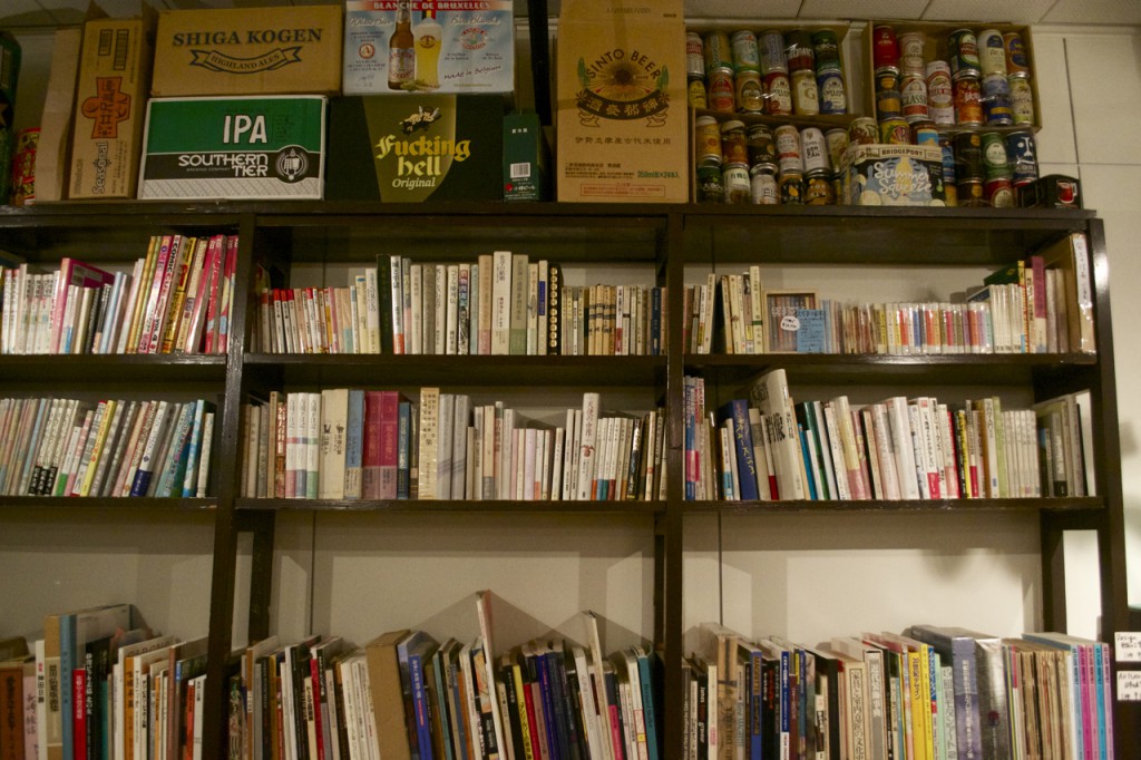 Bookshelves and beer boxes line the wall.